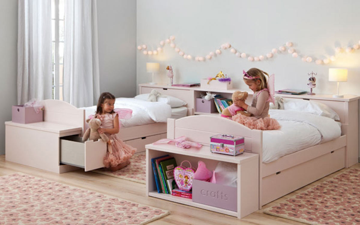 habitación infantil con dos camas nido en rosa y almacenamiento integrado